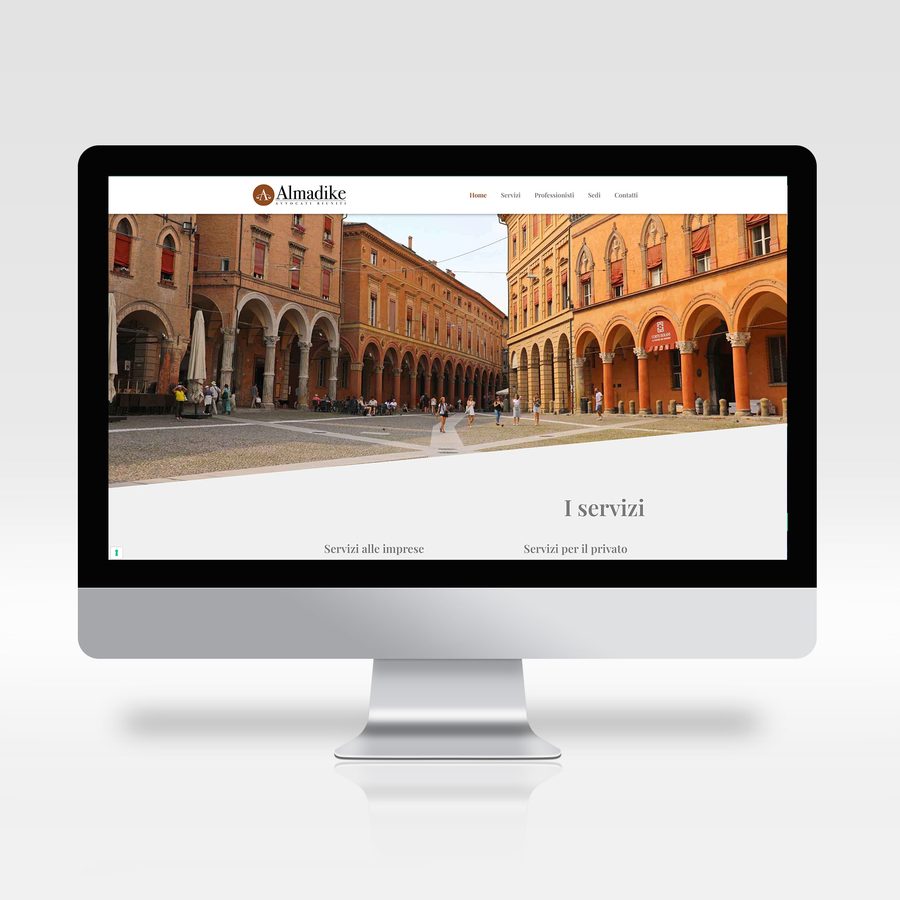 Almadike website on a monitor: homepage with a photo of Bologna's porticoes